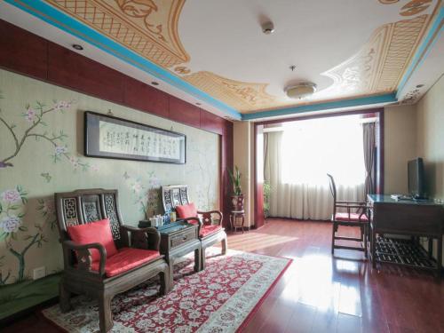 a living room with chairs and a piano on a wall at Beijing Inner Mongolia Hotel Chaoyang in Beijing
