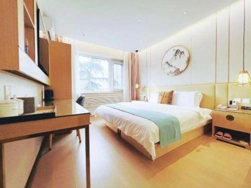 a bedroom with a bed and a desk and a window at Beijing Inner Mongolia Hotel Chaoyang in Beijing