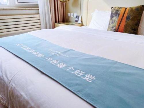 a sign on a bed in a hotel room at Beijing Inner Mongolia Hotel Chaoyang in Beijing