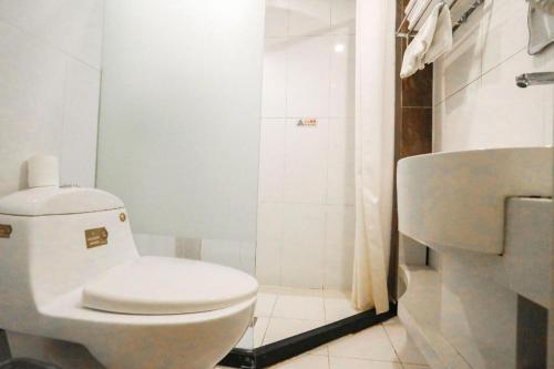 a white bathroom with a toilet and a shower at Beijing Inner Mongolia Hotel Chaoyang in Beijing