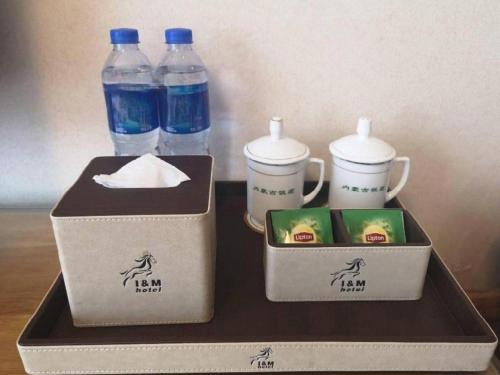 two boxes of water bottles and cups on a table at Beijing Inner Mongolia Hotel Chaoyang in Beijing