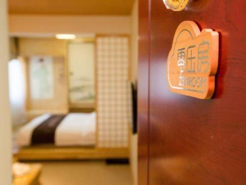 a sign on the door of a room with a bed at Beijing Inner Mongolia Hotel Chaoyang in Beijing