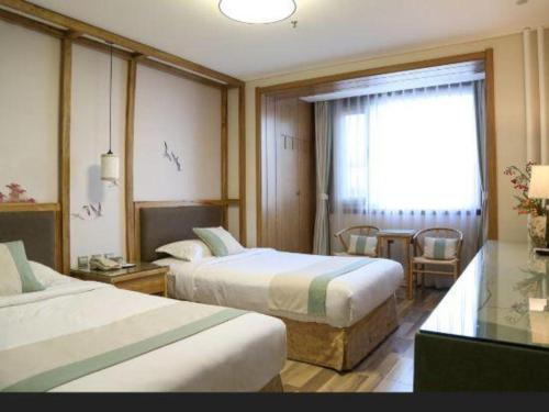 a hotel room with two beds and a window at Beijing Inner Mongolia Hotel Chaoyang in Beijing