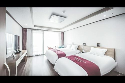 pokój hotelowy z dwoma łóżkami i telewizorem w obiekcie Jeju Sunbeach Hotel & Resort w mieście Czedżu