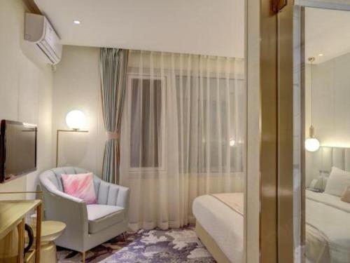 a bedroom with a bed and a couch and a chair at Beijing Inner Mongolia Hotel Chaoyang in Beijing
