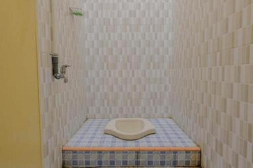 a bathroom with a toilet in the corner of a shower at Penginapan Arsyana in Pacitan