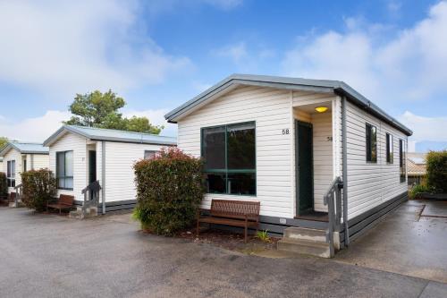 a small white house with a lot of windows at Airport Tourist Village Melbourne in Melbourne