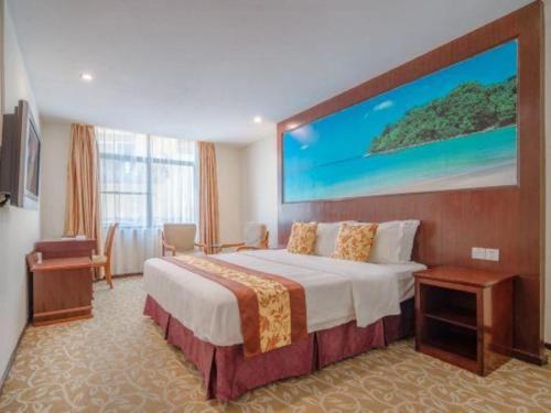 a hotel room with a large bed with a large painting on the wall at Zhaoqing Shanshui Fashion Hotel Duanzhou Road Branch in Zhaoqing