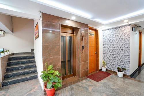 a hallway with a door and stairs with plants at FabHotel Divine & Banquet in Noida