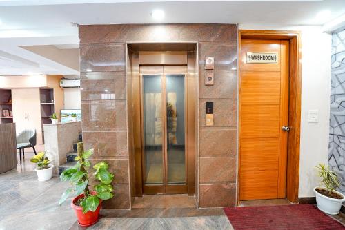 an office entrance with a wooden door and plants at FabHotel Divine & Banquet in Noida
