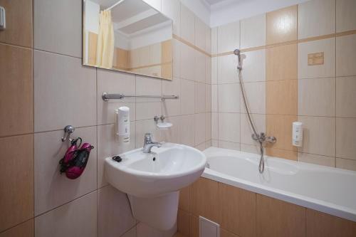 a bathroom with a sink and a bath tub at Kompleks Antałówka Termy & Med in Zakopane