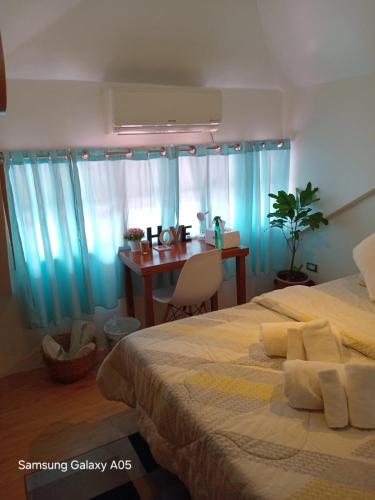 a bedroom with two beds and a table and a desk at ESPERANZA Pension House & Restaurant in Roxas