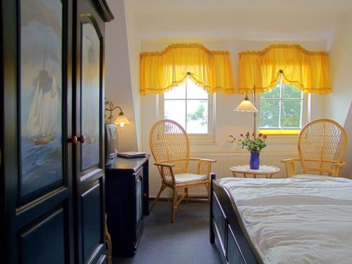 a bedroom with a bed and two chairs and a table at Hotel Gastmahl des Meeres in Sassnitz