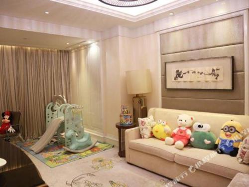 a living room with a couch with stuffed animals on it at Xian Jue Vu Hotel in Xi'an