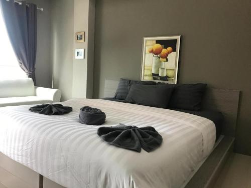 a bed with two black towels on top of it at The Residence Prachinburi in Si Maha Phot
