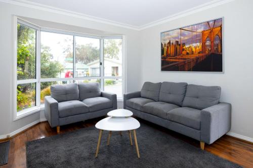 a living room with two couches and a table at Airport Tourist Village Melbourne in Melbourne