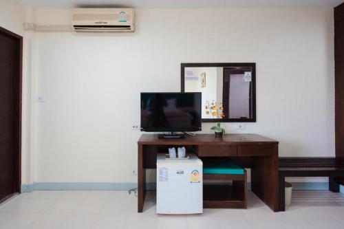 a desk with a computer and a television on it at Nice Beach Hotel in Rayong