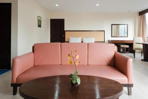 a pink couch in a living room with a table at Nice Beach Hotel in Rayong