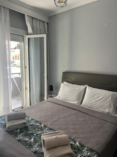 a bedroom with a bed with two towels on it at Egee Guest House in Néa Péramos
