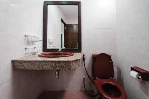 a bathroom with a red toilet and a mirror at Nice Beach Hotel in Rayong