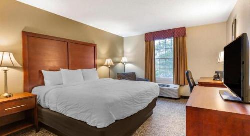 a hotel room with a bed and a flat screen tv at Comfort Inn Foxboro - Mansfield in Foxborough