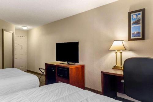 a hotel room with a bed and a desk with a television at Comfort Inn Foxboro - Mansfield in Foxborough