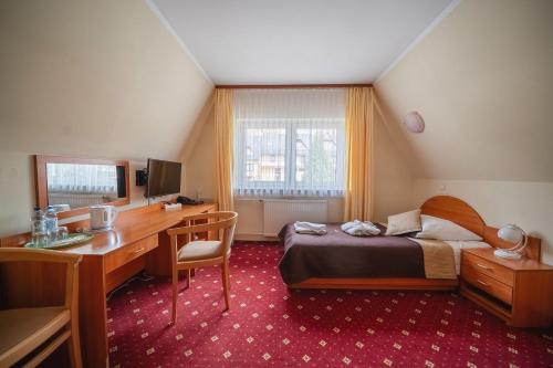 a bedroom with a desk and a bed and a desk and a computer at Kompleks Antałówka Termy & Med in Zakopane