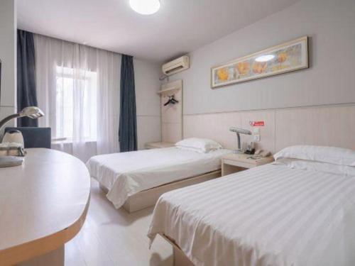 una camera d'albergo con due letti e una finestra di Jinjiang Inn Wuxi Li Lake Yauntouzhu Scenic Spot a Wuxi