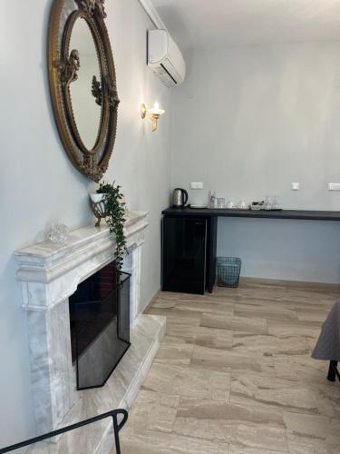 a living room with a fireplace and a mirror at Egee Guest House in Néa Péramos