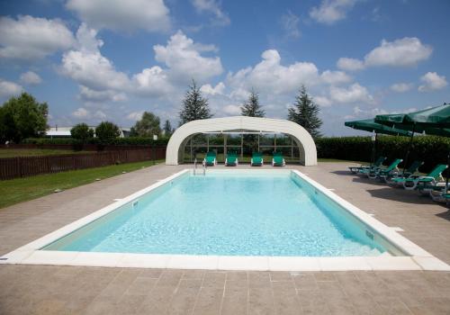 a swimming pool with chairs and a gazebo at Lo Scoiattolo Piedmont Bike Hotel in Pralormo