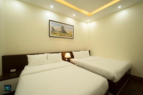 a hotel room with two beds and a picture on the wall at Cao Bang Eco Bistro & Stay in Cao Bằng