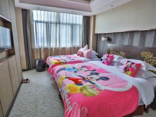 two beds in a hotel room with hello kitty beds at Dajiuhua Hotel in Chizhou
