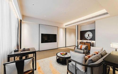 a living room with a couch and a tv at Dajiuhua Hotel in Chizhou