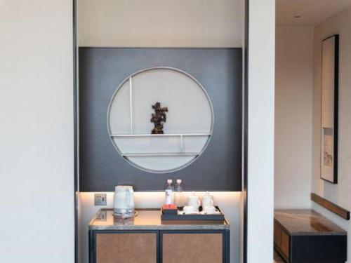 a bathroom with a mirror and a table with a sink at Dajiuhua Hotel in Chizhou