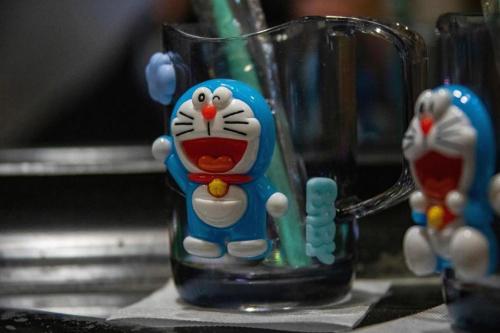 a glass mug with a cat figurine on a counter at Dajiuhua Hotel in Chizhou