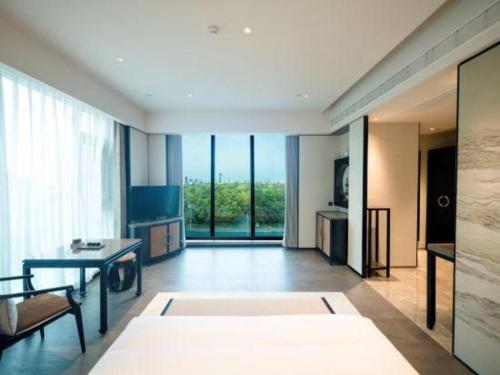 a living room with a table and a large window at Dajiuhua Hotel in Chizhou