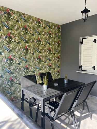 a dining room with a table and chairs with a wallpaper at Egee Guest House in Néa Péramos