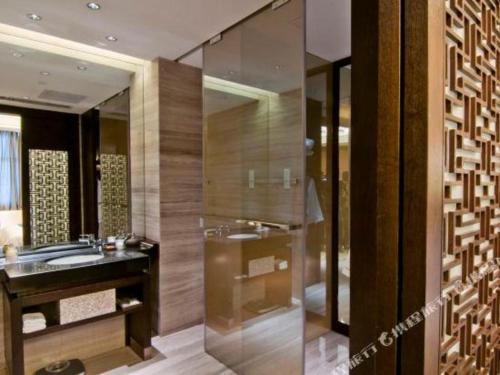 a bathroom with a sink and a large mirror at Dajiuhua Hotel in Chizhou