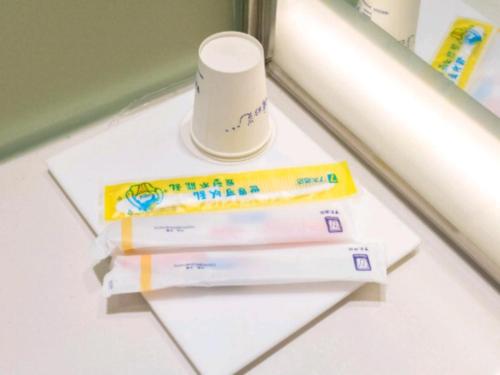 a stack of toothbrushes and a tube of toothpaste at 7 Days Inn·Ulanqab Tsining railway station in Ulanqab