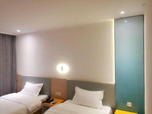 a hotel room with two beds and a mirror at 7 Days Inn·Ulanqab Tsining railway station in Ulanqab