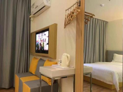 a hotel room with a bed and a television at 7 Days Inn·Ulanqab Tsining railway station in Ulanqab
