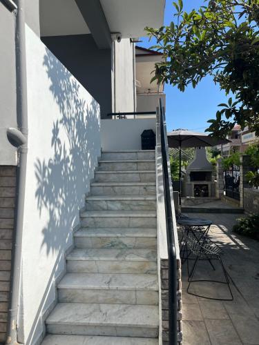 a staircase leading up to a house with a table at Egee Guest House in Néa Péramos