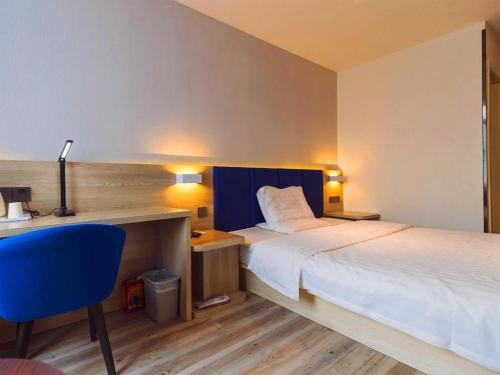 ein Hotelzimmer mit zwei Betten und einem Schreibtisch und einem Stuhl in der Unterkunft 7 Days Premium·Tianjin Gulou Metro Station Joy City in Tianjin