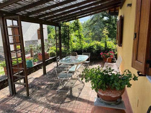 a patio with a glass table and chairs at Casale Vera in Sagginale