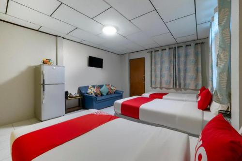 two beds in a room with red pillows at OYO 75322 Tha Burapa Resort Bangsean in Ban Laem Thaen