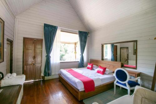 a bedroom with a large bed and a mirror at OYO 75374 Baan Rak Mai in Kanchanaburi