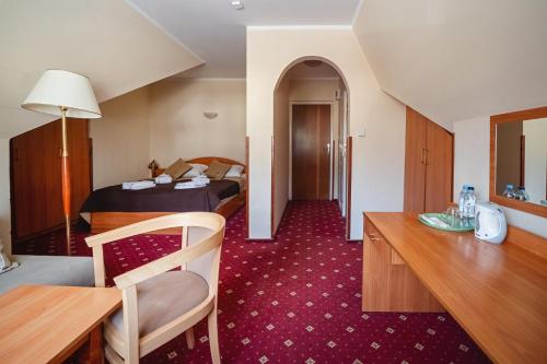 a hotel room with a bed and a desk at Kompleks Antałówka Termy & Med in Zakopane
