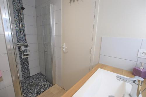 une salle de bain avec une douche avec une porte vitrée dans l'établissement Appartement avec piscine et accès direct à la mer, à Châtelaillon-Plage