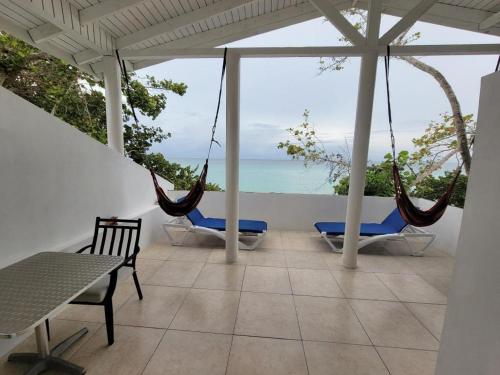 a patio with hammocks and a view of the ocean at Merrils Deluxe in Negril