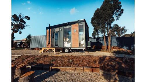 a tiny house on a trailer in a yard at Farm Stay at Sheltered Paddock by Tiny Away in Warrenmang